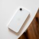 iPhone 16e branco em cima de uma mesa com a tela para baixo