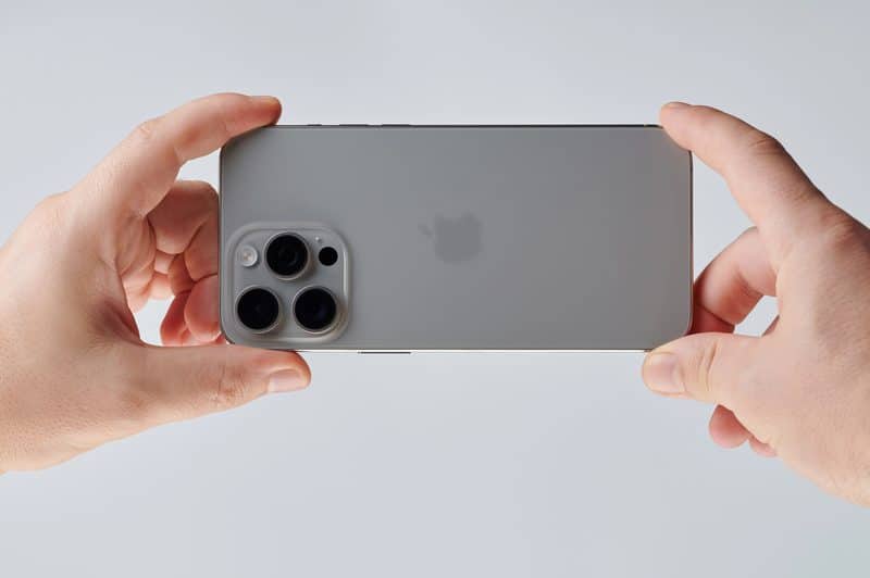 Traseira do iPhone/homem segurando um iPhone