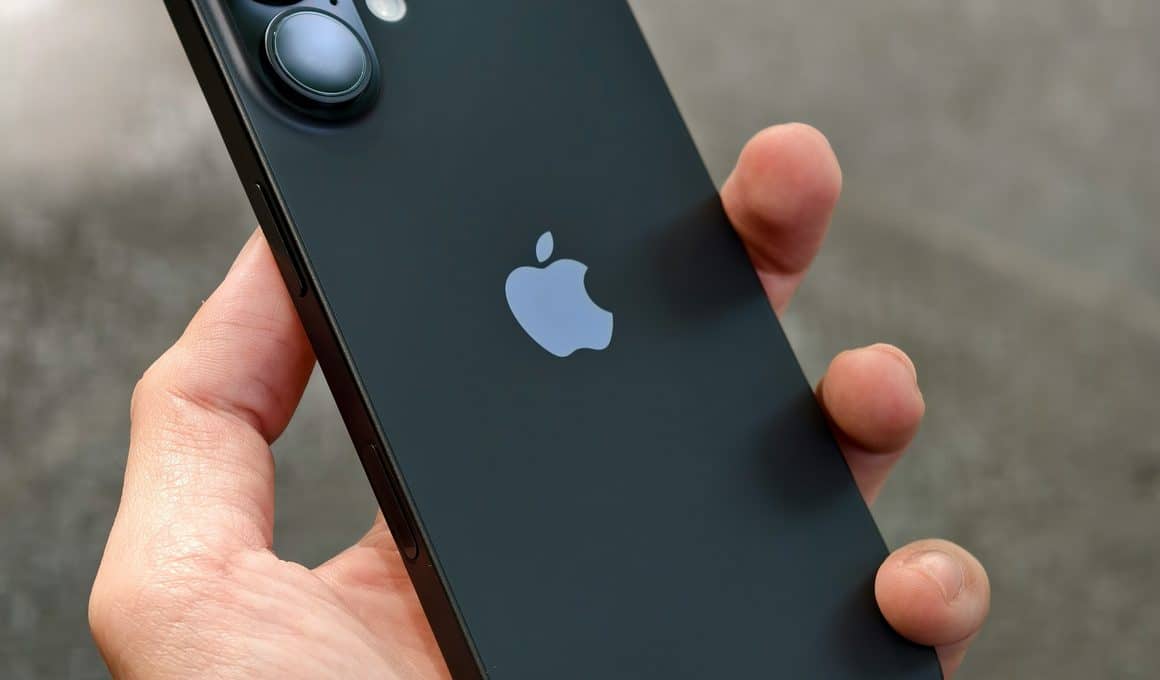 Mão segurando um iPhone 16 preto