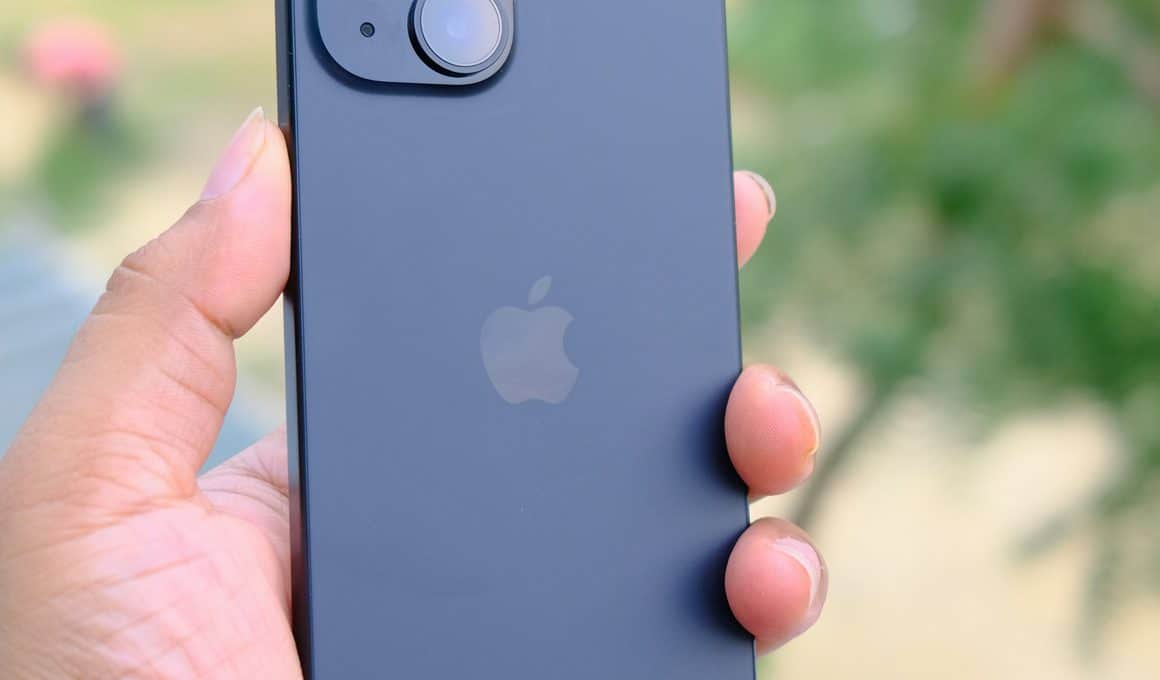 Mão segurando um iPhone 15 preto