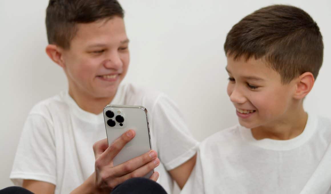 Dois irmãos usando um iPhone 13 Pro Max