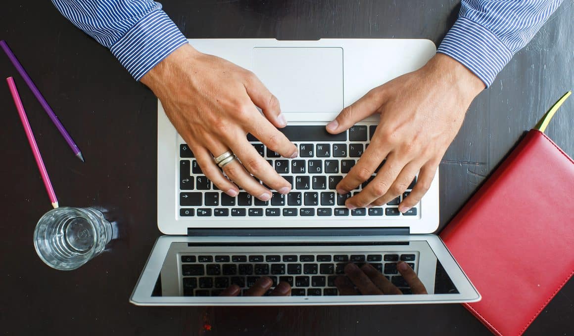 Homem trabalhando/digitando em MacBook