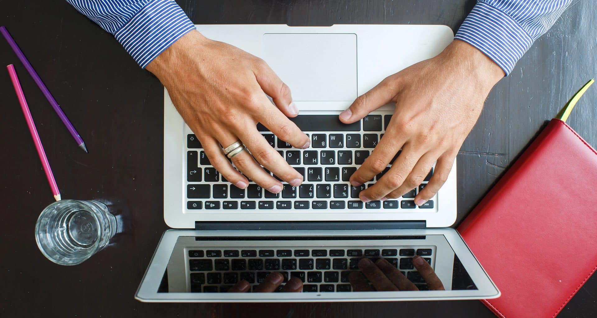 Homem trabalhando/digitando em MacBook