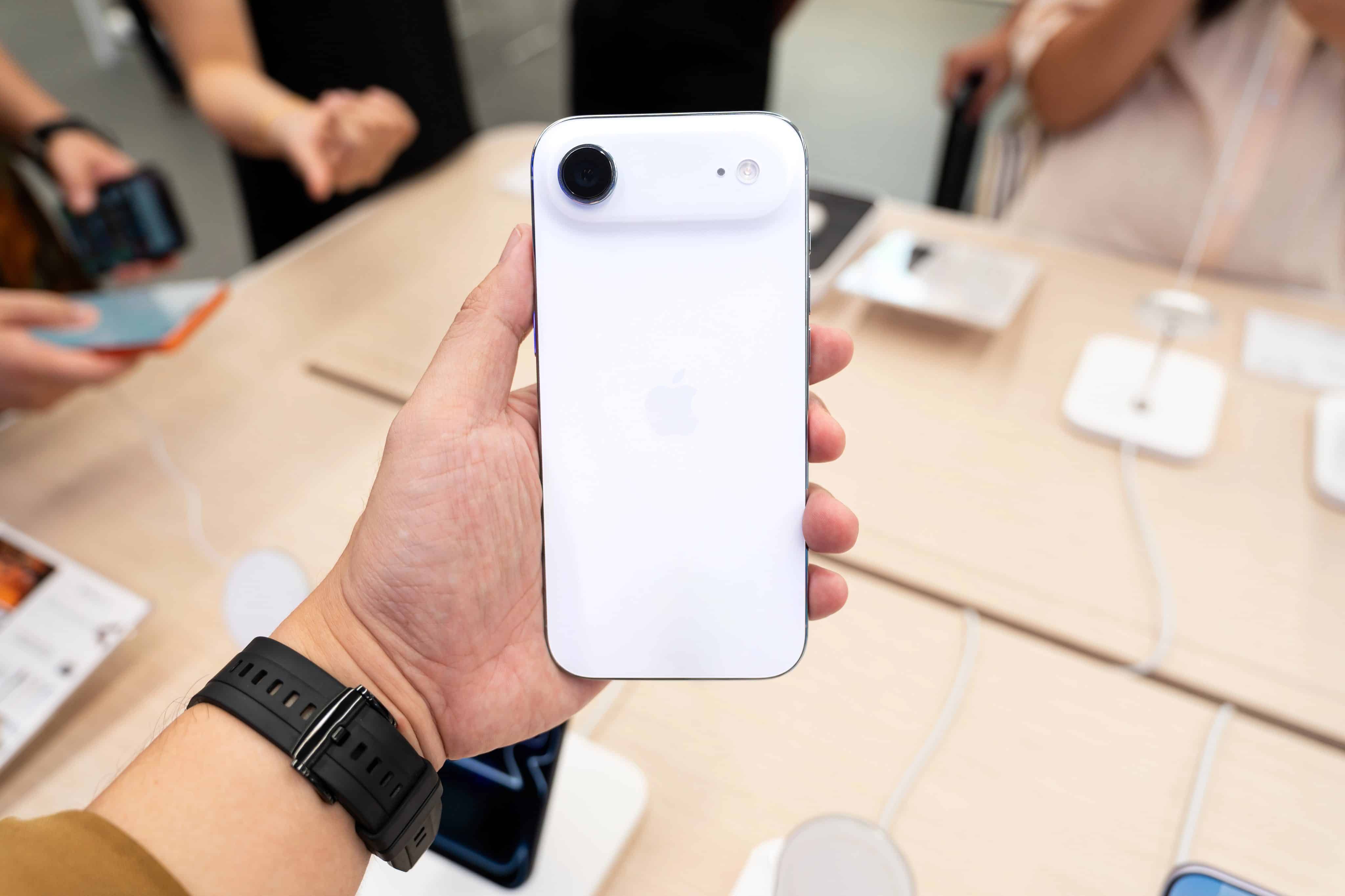 Mão segurando um iPhone Air dentro de uma loja da Apple