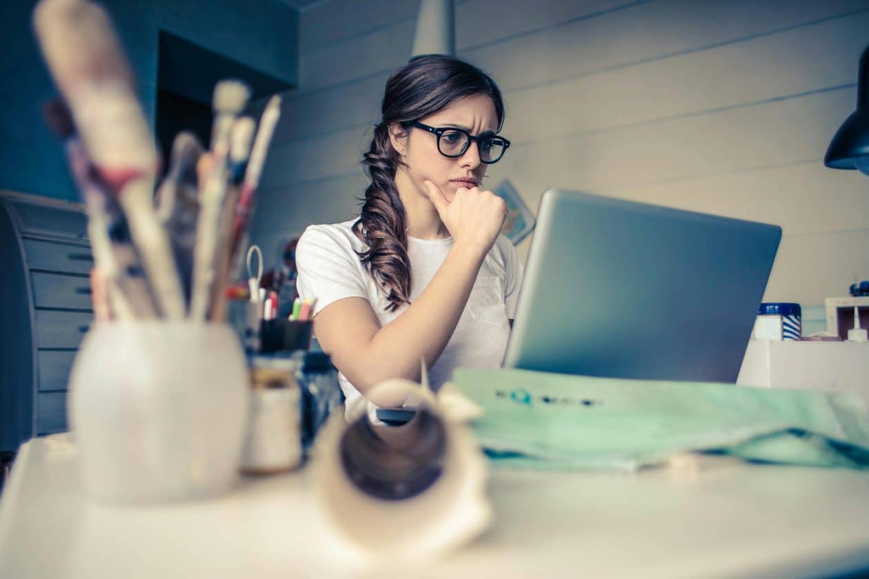 Mulher pensando enquanto olha para o computador