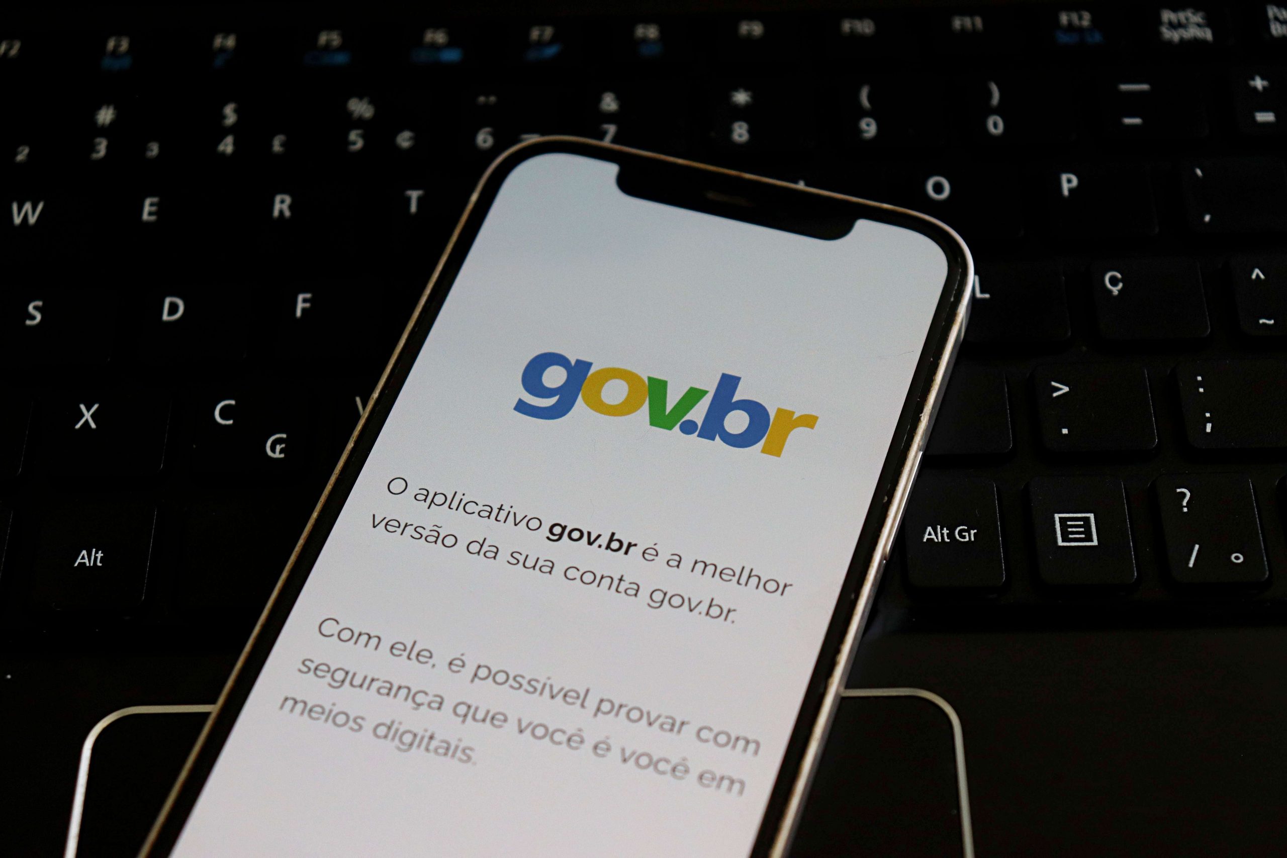 Gov.br no iPhone em cima de um teclado de computador