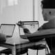 Dois homens numa sala conversando e usando Macs